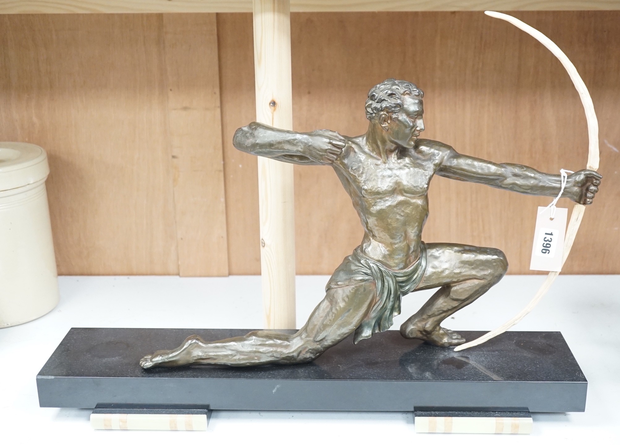 A 1930's patinated spelter figure of an archer, on a marble base, 60cms wide